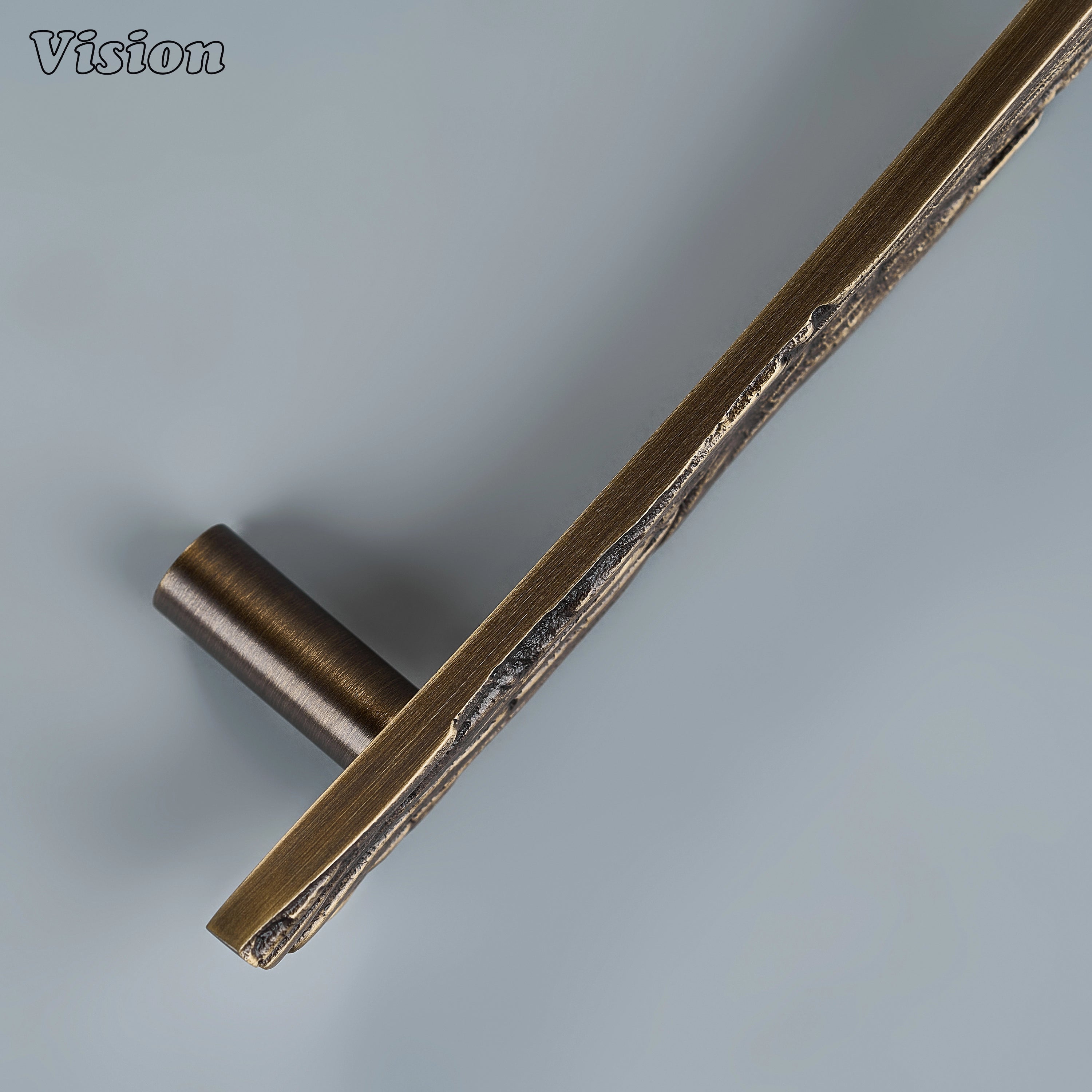 Textured antique bronze sculpted drawer pull with sweeping grooves on custom kitchen cabinetry