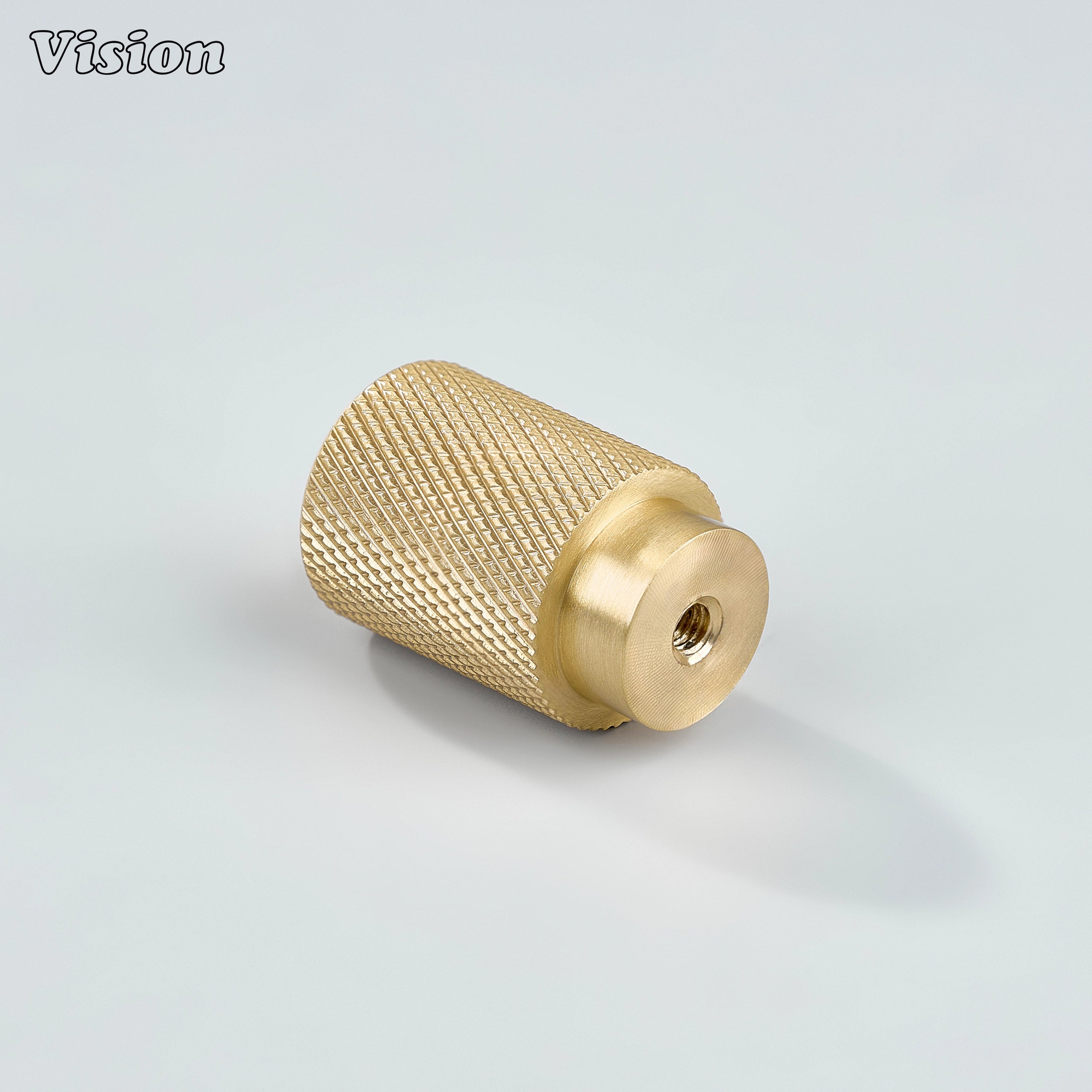 Modern gold knurled cylinder knob used for dresser drawers.