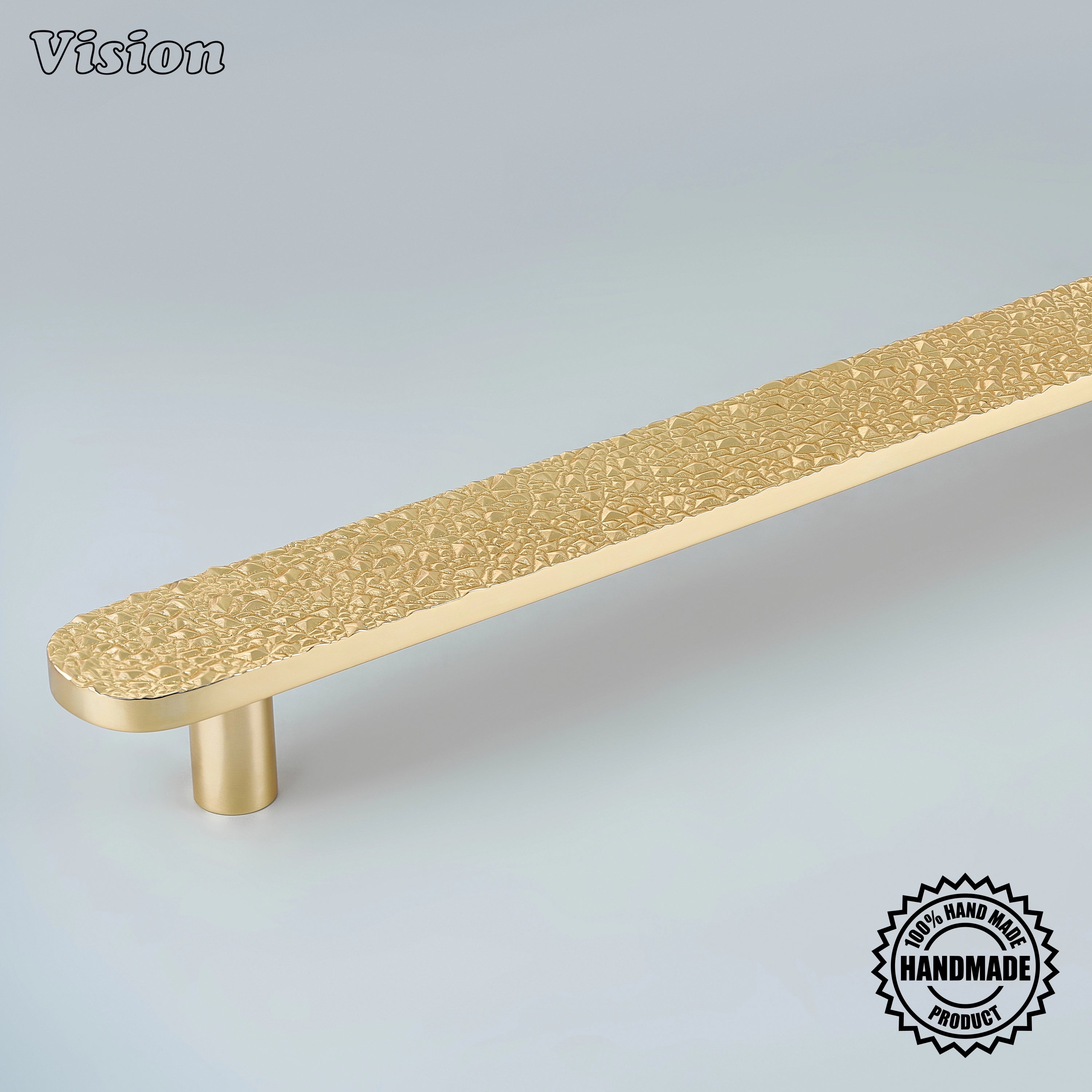 Sculpted polished brass appliance handle with crushed stone relief mounted on panel refrigerators