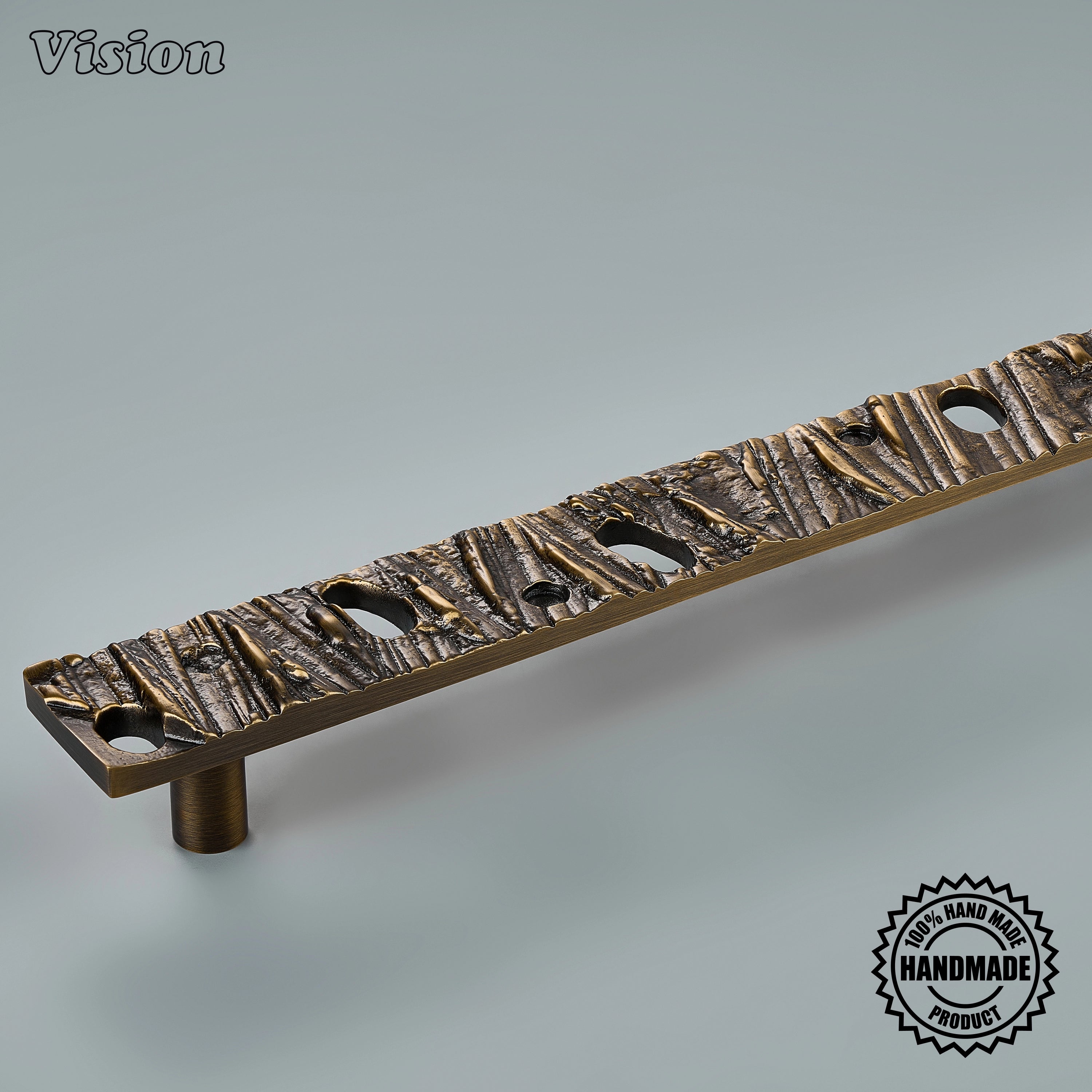 Sculpted antique bronze appliance pull with hollow accents mounted on integrated refrigerators