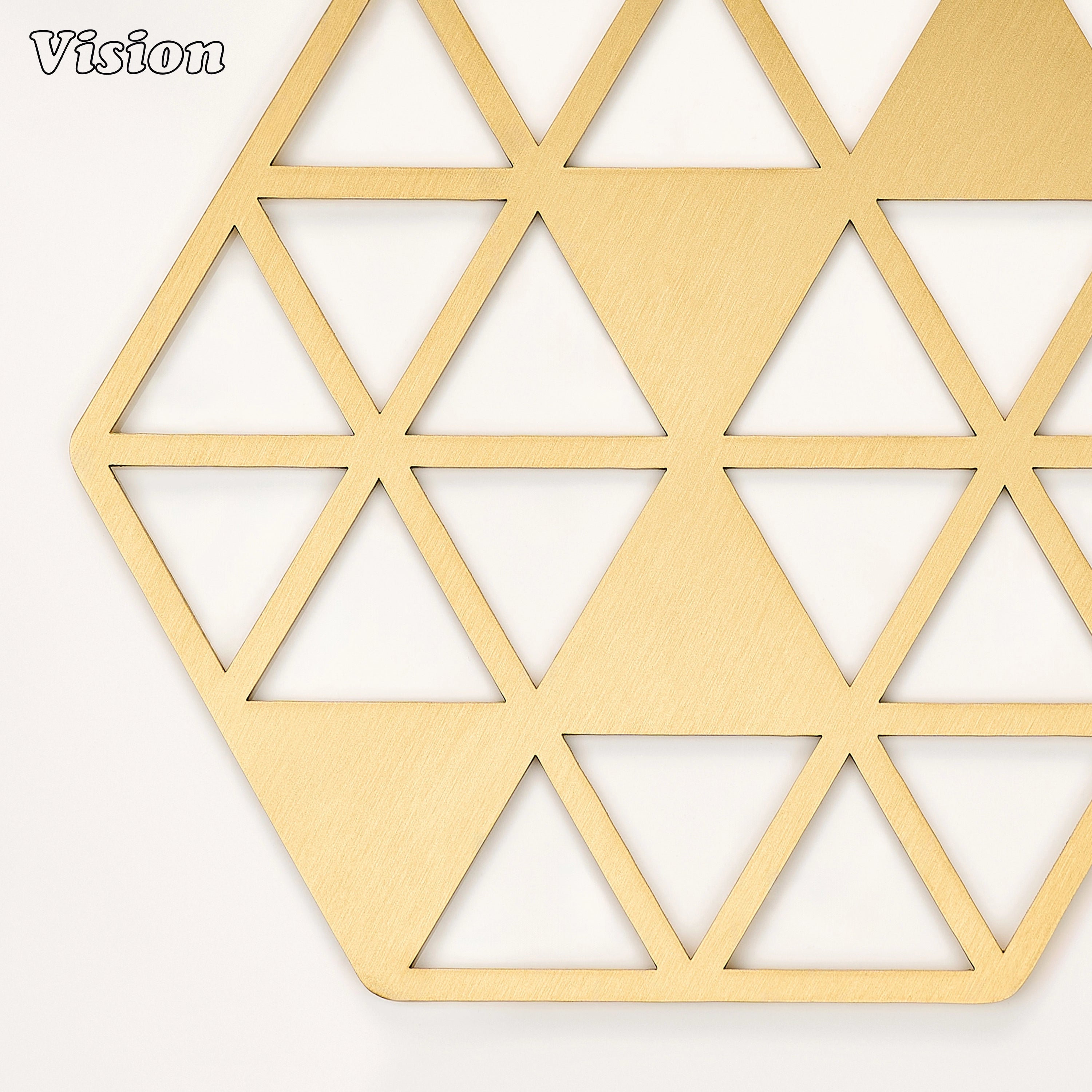 Heavy gold solid brass drink coaster with sharp faceted cutouts on a contemporary office desk